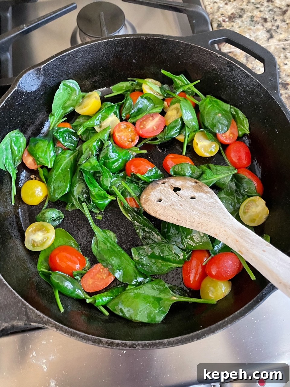 The spinach and cherry tomatoes for the Easy Weekend Breakfast Skillet in the skillet