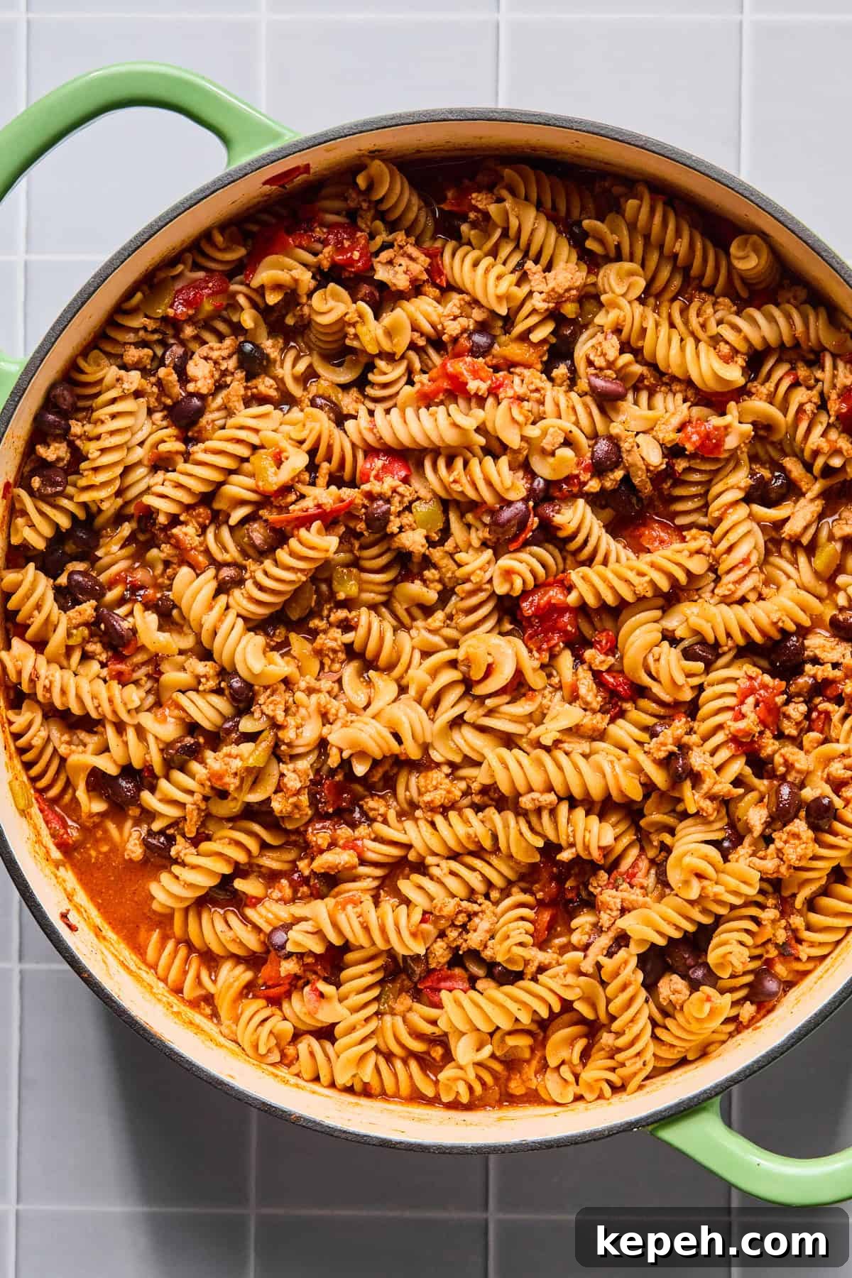 One pot taco pasta simmering in broth as the pasta cooks and absorbs the sauce.