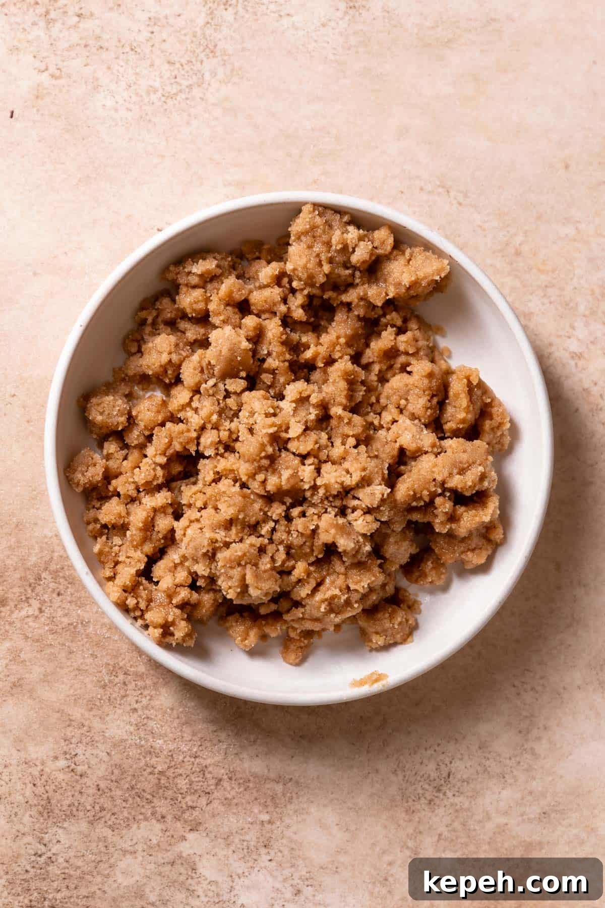 A white bowl with cinnamon crumb topping.