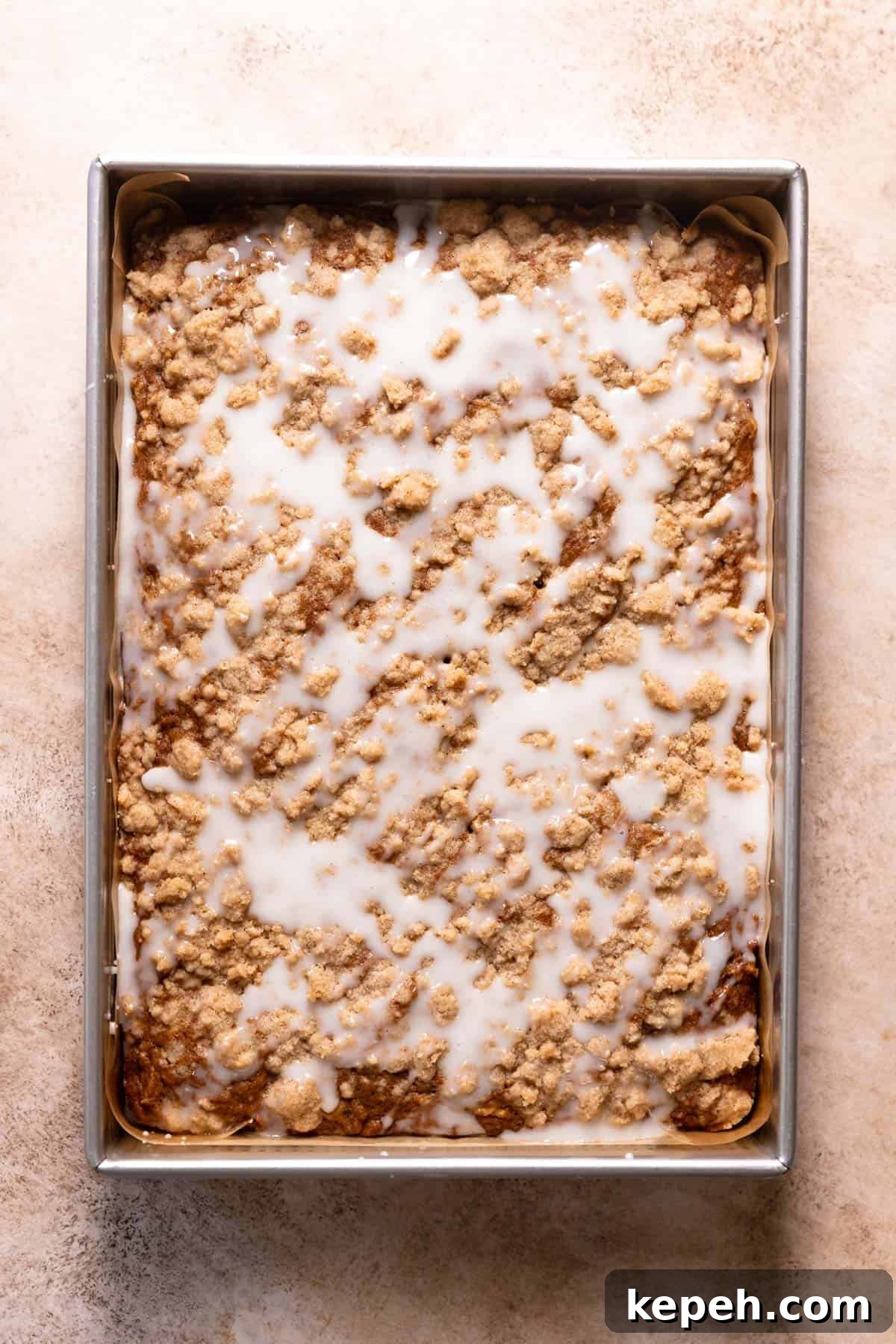 Apple cinnamon cake with vanilla glaze poured over the top.