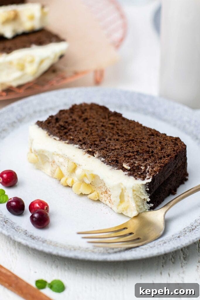 Moist Gluten-Free Gingerbread Loaf Recipe 2 A slice of gluten free gingerbread shown topped with a white chocolate marscapone.