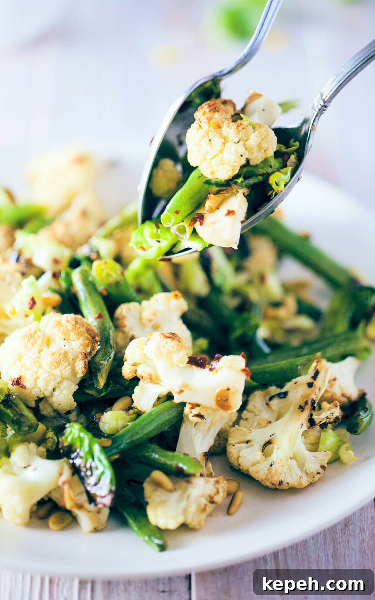 Roasted Cauliflower and Brussels Sprout Salad with Lemon 2 Scooping roasted cauliflower and brussels sprout salad with serving spoons
