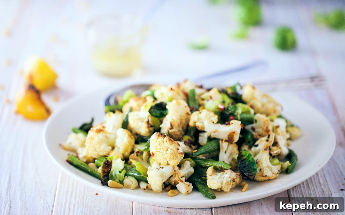 Roasted Cauliflower and Brussels Sprout Salad with Lemon 7 Side view of roasted cauliflow and brussels sprout salad on a white wooden background