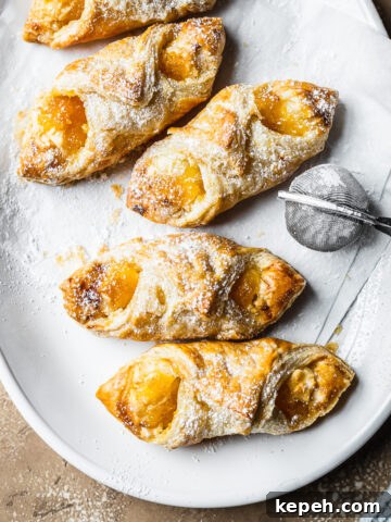 Baked pastries on white parchment on a white ceramic plate.