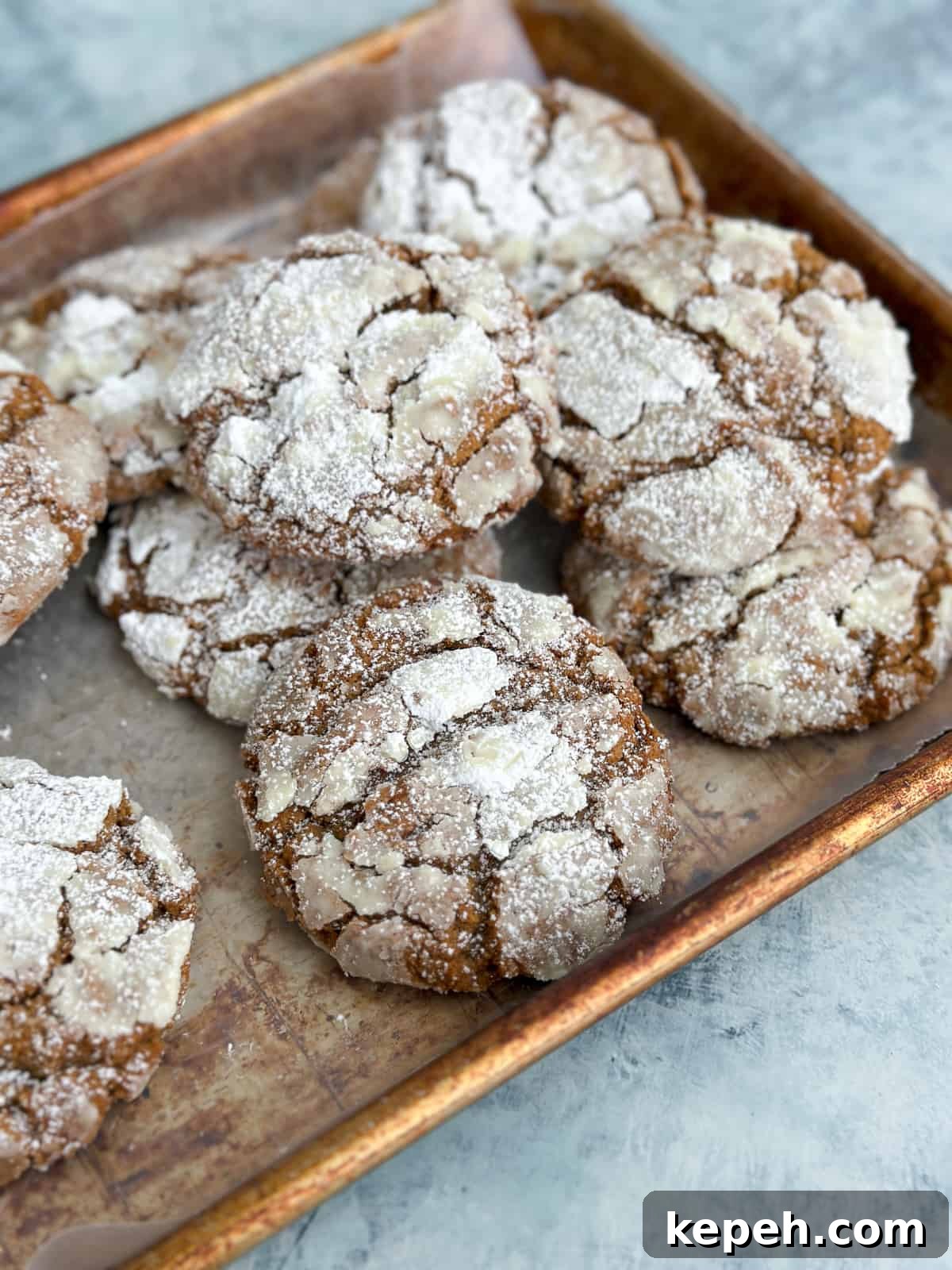 a stack of molasses crinkle cookies on a baking sheet.