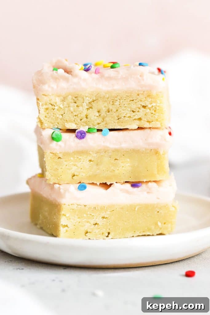 Fudgy Gluten-Free Brookies: Brownie Cookie Bars 9 three sugar cookie bars with pink frosting stacked on a white plate